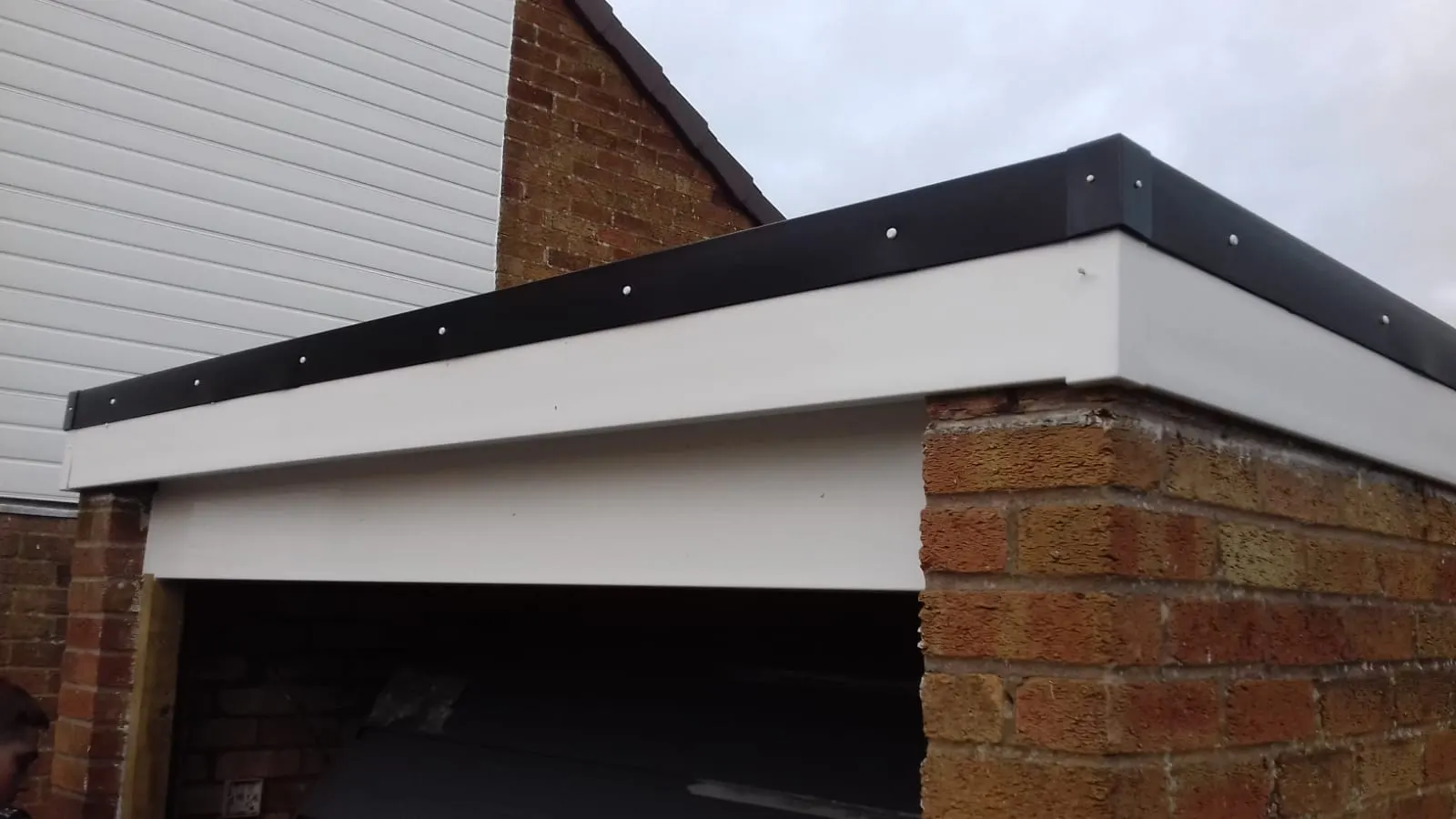 New fascia trim along a flat roof edge