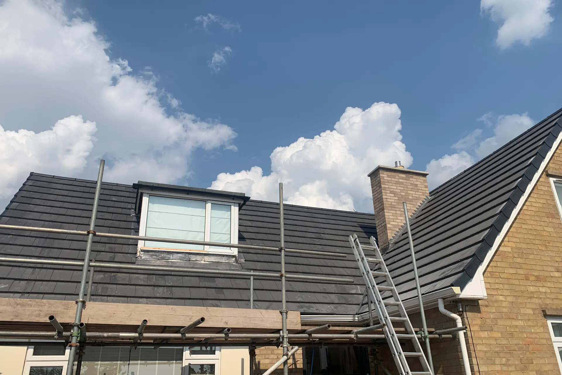A new grey tiled roof with a dormer, fitted by Property Fix Roofing Solutions Ltd